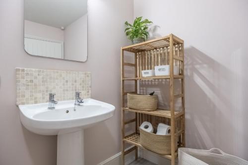 y baño con lavabo y estante. en Water Mill House, en Burnham Market