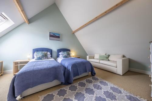 a bedroom with two beds and a couch at Water Mill House in Burnham Market