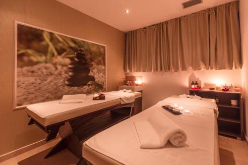 a room with two beds and a table at Hotel Sirius Spa & Wellness in Strumica