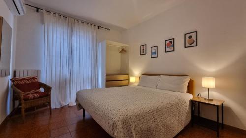 1 dormitorio con 1 cama, 1 silla y 1 ventana en BeBelle Casa Vacanze, en Polignano a Mare