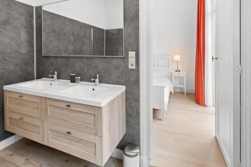 y baño con lavabo y espejo. en Apartment in Brussels, Lantsheere by Homenhancement SA en Bruselas