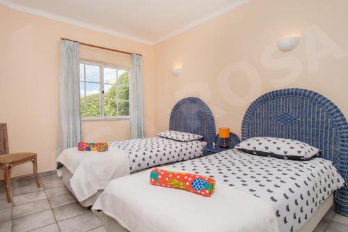 1 dormitorio con 2 camas y ventana en Quinta do Rosal, Casa Rosa, en Carvoeiro