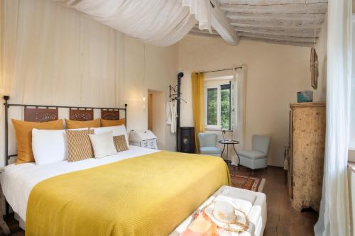 ein Schlafzimmer mit einem großen Bett und einer gelben Decke in der Unterkunft Amore Rentals - Casale della Toscana in San Casciano dei Bagni