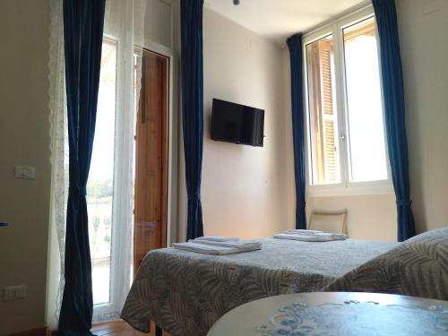 a bedroom with two beds with blue curtains and a window at Villa Incina - Sea House in Polignano a Mare