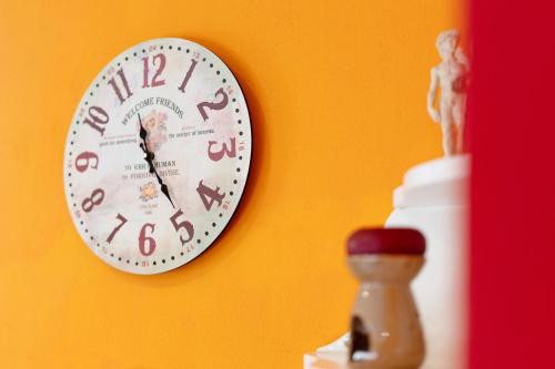 a clock hanging on a wall next to a figurine at Casa Bella in Intra
