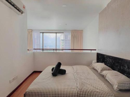 Eine schwarze Katze sitzt auf einem Bett in einem Schlafzimmer. in der Unterkunft Duplex 4PX Free Parking @ ICITY, Near SOGO & ThemePark in Shah Alam