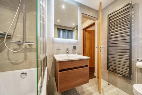 een badkamer met een wastafel en een douche bij Modern Bowness-on-Windermere Flat - Free Parking in Bowness-on-Windermere