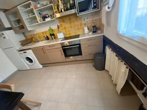 - une petite cuisine avec des appareils blancs et du carrelage jaune dans l'établissement Chambre 2 personnes dans appartement, à Paris
