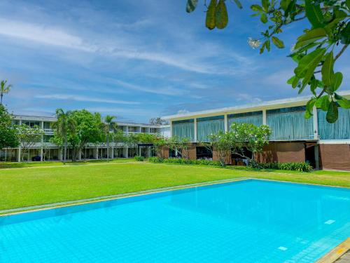 a swimming pool in front of a building at Pegasus Reef - A Beach Resort in Colombo in Colombo