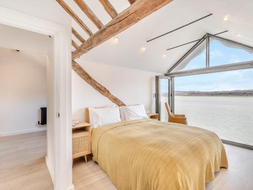 a bedroom with a large bed and a large window at Beach Haven in Arnside