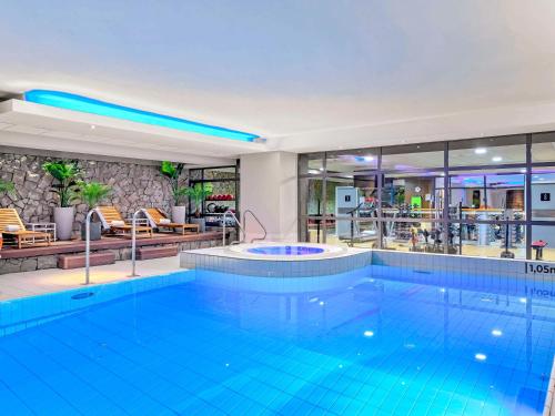 a large swimming pool in a hotel lobby at Novotel Kraków Centrum in Kraków