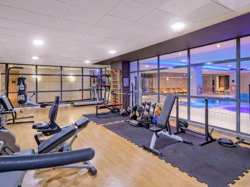 a gym with cardio equipment and a swimming pool at Novotel Kraków Centrum in Kraków