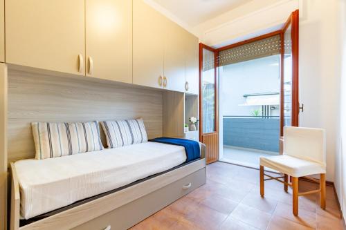 1 dormitorio con 1 cama grande y 1 silla en Appartamento Alba Rosa 3 - MyHo Casa, en Alba Adriatica