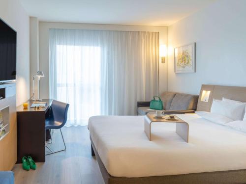 巴塞隆納的住宿－諾富特巴塞羅那城市酒店，酒店客房设有一张大床和一张书桌。
