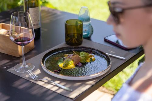 a table with a plate of food and a glass of wine at Locanda dell'Aioncino in Bibbona