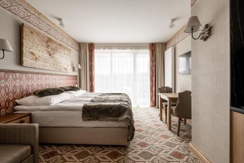 a hotel room with a bed and a desk at Aries Residence Bukowina in Bukowina Tatrzańska