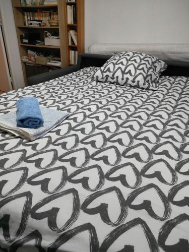 - un lit avec une couette en noir et blanc et un oreiller dans l'établissement Chambre 2 personnes dans appartement, à Paris
