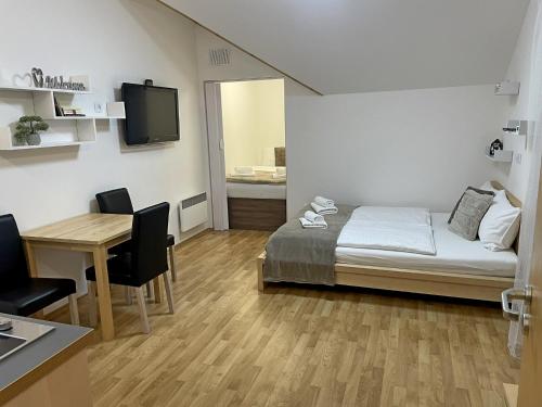 a bedroom with a bed and a desk and a table at Martinske Hole, Apartman, Nova Ponorka in Martin