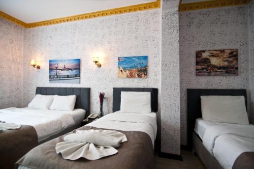 two beds in a room with paintings on the wall at Golden Horn Park Hotel in Istanbul