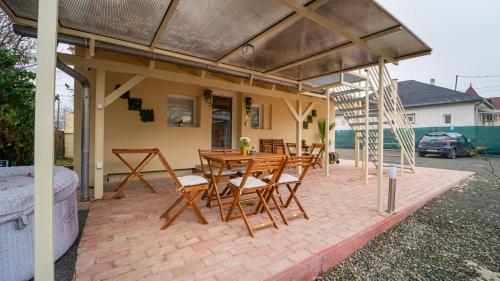 un patio con mesa de madera y sillas en Palmy Home Dunakeszi en Dunakeszi
