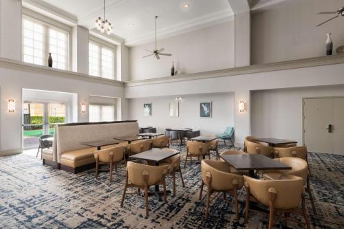 a large room with tables and chairs and windows at Homewood Suites by Hilton Lake Mary Orlando North in Lake Mary