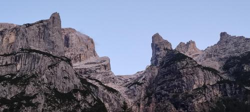 a rocky mountain with a blue sky in the background at Appartamenti Codàn in San Vito di Cadore