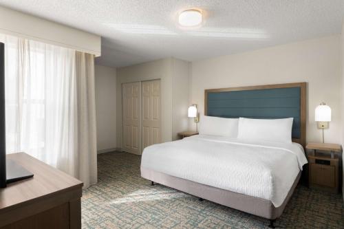 a bedroom with a large bed and a large window at Homewood Suites by Hilton Lake Mary Orlando North in Lake Mary