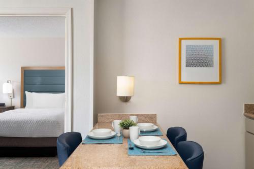a hotel room with a table and a bed at Homewood Suites by Hilton Lake Mary Orlando North in Lake Mary