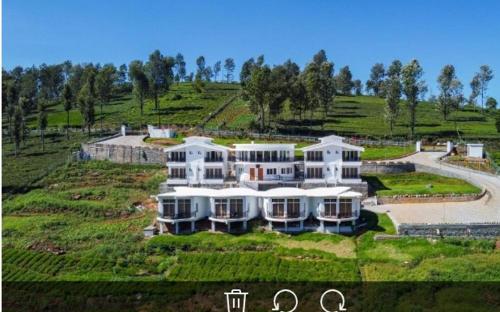 an aerial view of a large house in a field at COASTAL GRAND RESORT - KOTAGIRI in Kotagiri