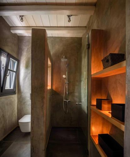 a bathroom with a shower and a toilet at Myconian Platinum Senior & Deluxe Villas in Kalafatis