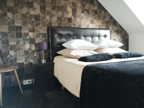 Schlafzimmer mit einem Bett mit einem schwarzen Kopfteil und Kissen in der Unterkunft Sweetnest by home in Waterloo