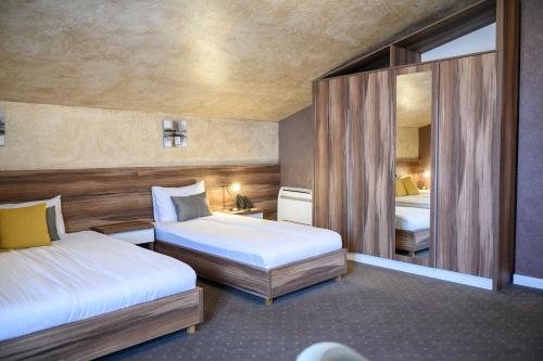 Habitación de hotel con 2 camas y espejo en MV Monogram, en Inđija