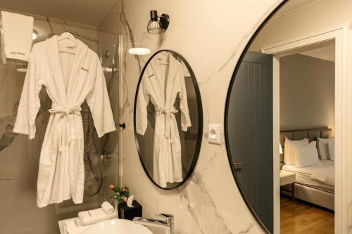 a bathroom with a mirror and a white robe at Armerun Heritage Hotel & Residences in Šibenik
