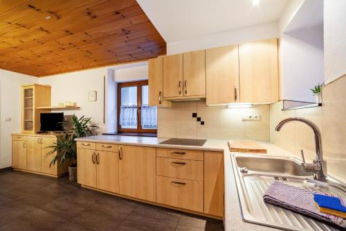 a kitchen with wooden cabinets and a sink at Wohnung Gravensteiner Schnalserhof in Laces