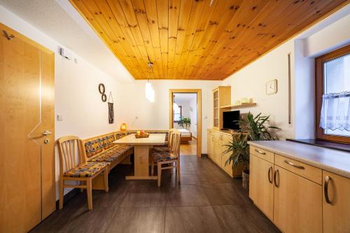 a kitchen with a wooden ceiling and a table and chairs at Wohnung Gravensteiner Schnalserhof in Laces