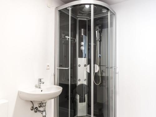 ein Bad mit einer Glasdusche und einem Waschbecken in der Unterkunft Apartment in Brussels, Degroux by Homenhancement SA in Brüssel