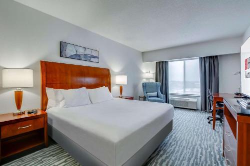 a hotel room with a large bed and a window at Hilton Garden Inn Louisville-Northeast in Louisville