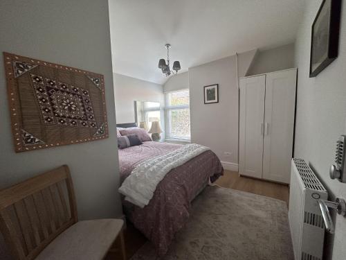 1 dormitorio con cama y ventana en Adanhouse-stockland spacious 5 bedroom house sleeps 12 private garden, en Cardiff