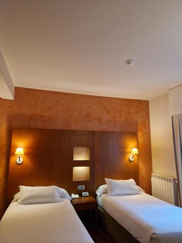 a hotel room with two beds and two lights at Hotel Maroa Vigo in Vigo