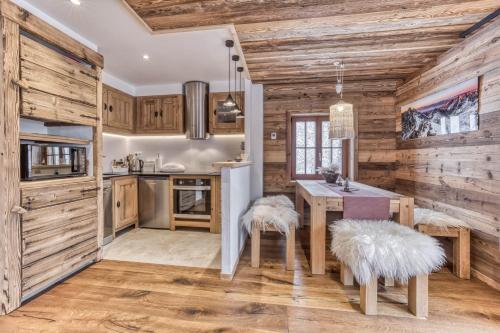 - une cuisine avec des murs en bois et une table avec deux tabourets dans l'établissement Chalet 3 étoiles pour 4 pers avec vue imprenable sur la vallée de Chamonix, aux Houches
