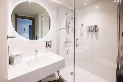 a white bathroom with a sink and a shower at Hampton By Hilton Blackpool in Blackpool