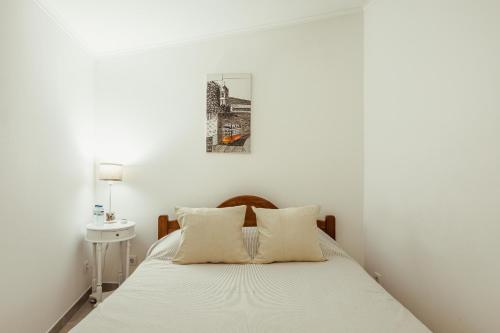 a bedroom with a bed with a picture on the wall at Algés Village Casa 4 by Lisbon-Coast vacation in Algés