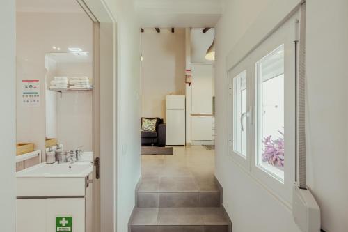 - un couloir avec une salle de bains pourvue d'un lavabo et d'une fenêtre dans l'établissement Algés Village Casa 4 by Lisbon-Coast vacation, à Algés