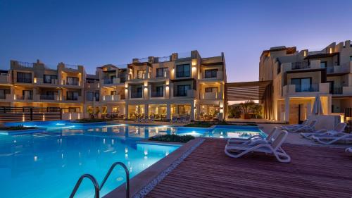 Creek Hotel and Residences El Gouna في الغردقة: فندق فيه مسبح امام المباني