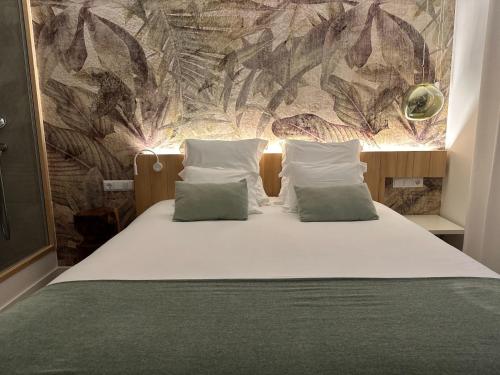 um quarto com uma cama com duas almofadas em Charm-In Center em Vila Nova de Milfontes