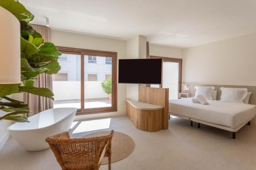 a bedroom with a bed and a tv in it at Reina Victoria Velázquez in Alicante