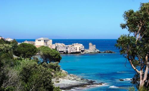 eine Gruppe von Häusern auf einem Hügel neben dem Meer in der Unterkunft Demeure Castel Brando Hôtel & Spa in Erbalunga