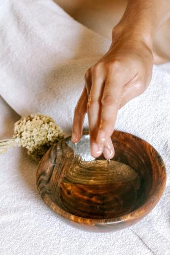a woman holding a wooden bowl with her hand at Demeure Castel Brando Hôtel & Spa in Erbalunga