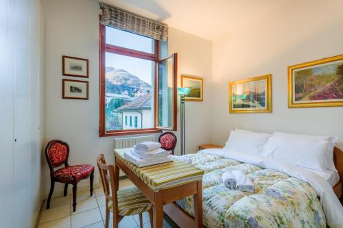 una camera con letto, tavolo e finestra di Regal Villa with Como Lake View and Free Parking a Bellagio