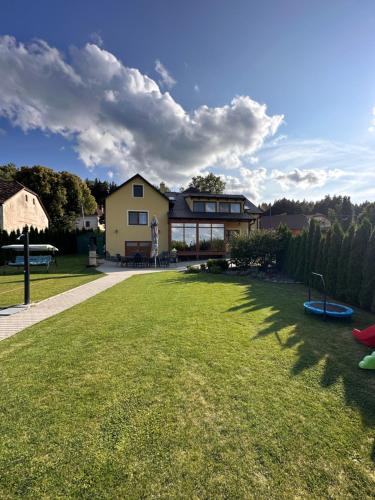 a house with a large yard with a playground at Vila v Brdech s bazénem, infra saunou a vybavením in Malá Víska